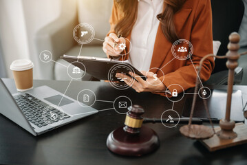 justice and law concept. Female judge in a courtroom the gavel, working with smart phone and laptop and digital tablet computer on table with VR icon