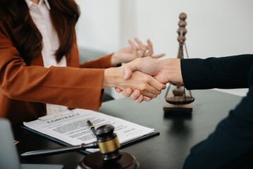Woman lawyer hand and women client shaking hand collaborate on working agreements with contract...