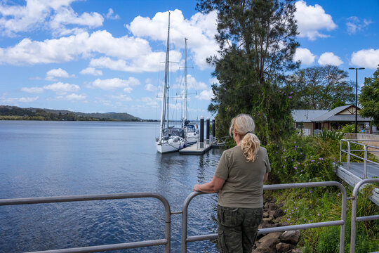 Woman tourist viewing yachts moored at a jetty