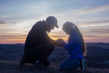 Dad and daughter. Prayer in the circle of the family holding hands. Father's Day Dad hugs the...