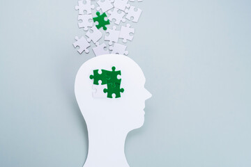 Eco-anxiety affecting mental health. Paper cutting head with green puzzles in grey background. Environmental awareness and eco education.  - obrazy, fototapety, plakaty