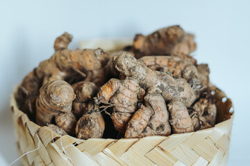 Ginger covered with soil on a bamboo basket after harvesting
