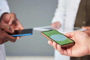 Hands, phone screen or data sharing for business people networking in office while standing in a huddle. Mobile, information technology and communication with an employee team connecting to database
