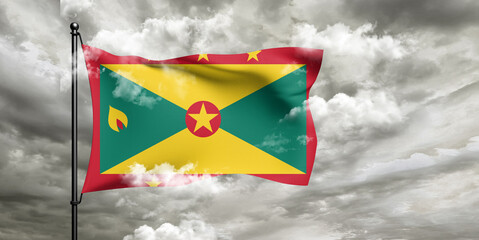 Grenada national flag cloth fabric waving on beautiful sky grey Background.