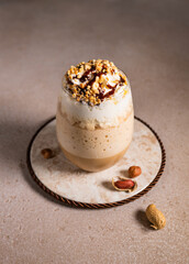 Coffee nuts milkshake with whipped cream and chocolate, cold summer cocktail.