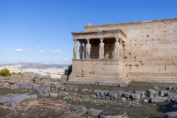 Erechtheion, Temple of Athena Polias on Acropolis of Athens, Greece. View of The Porch of the Maidens with statues of caryatids. Aerial view of the city in the distance