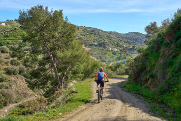 nice senior woman cycling with her electric mountain bike in the Sierra de Tejada near Nerja, Andalusia, Spain