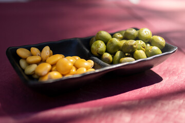 Comer unos aperitivos de altramuces y aceitunas