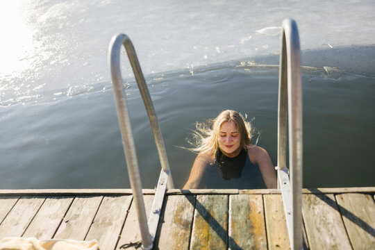 Woman swimming in lake at winter