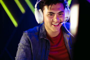 Happy male gamer looking at his computer screen during an online video game