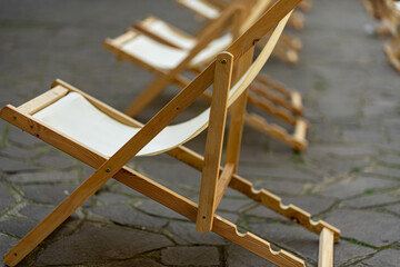 Lots of wooden deck chairs photographed with bokeh effect.