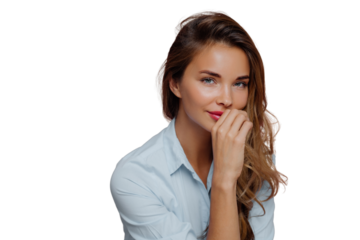 Photo of self assured attractive woman with long hair, keeps hand on lips, dressed in blue shirt, looks at camera with blue eyes, wears makeup, poses against purple background. Human face expressions