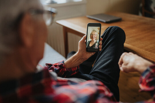 Senior man talking to woman via video call