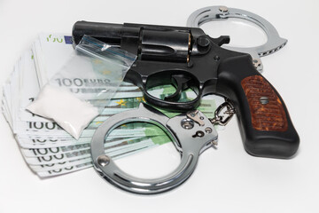Revolver, euro, handcuffs and a bag of white powder on a white background. The concept of...