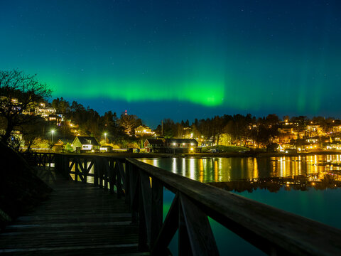 Northern lights over village on coast