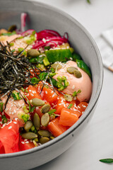 Portion of gourmet salmon poke bowl with vegetables