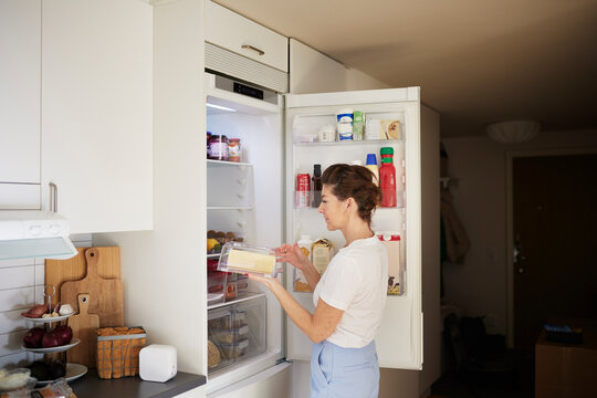 Woman standing in front of open fridge