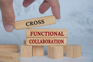 Hand placing wooden blocks with cross functional collaboration text on wooden blocks. Operational...