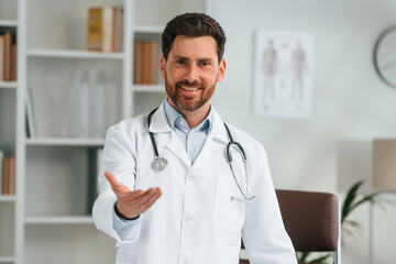 Standing in the office. Doctor in formal clothes is working in the cabinet