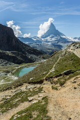 Fototapeta na wymiar Bonito paisaje de lago alpino con montaña y nubes en el fondo