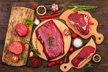 Set of various steaks with spices. Cuts includes ribeye, eye round, flank and striploin steaks