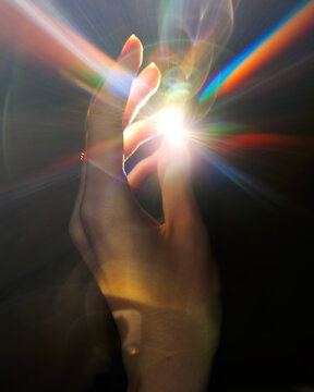 Colorful light in the human hands in the dark, stock photo and image