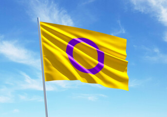 Intersex flag waving in a blue sky background for LGBTQIA+ Pride month, sexuality freedom, love diversity celebration and the fight for human rights in 3D illustration
