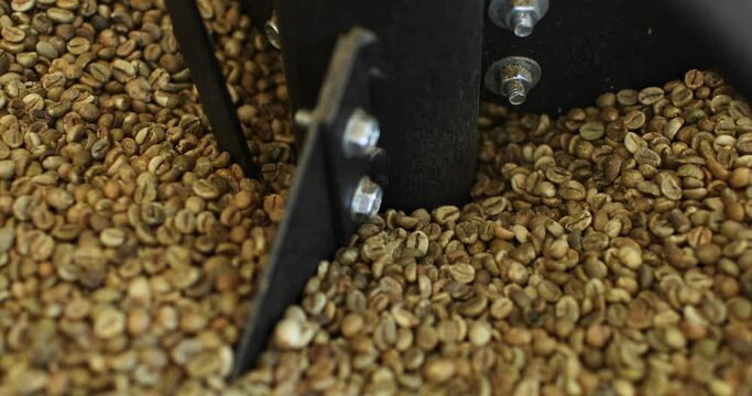Close-up. Coffee beans are roasted in a vat at the factory. Modern equipment. Industrial cooking arabica and robusta.