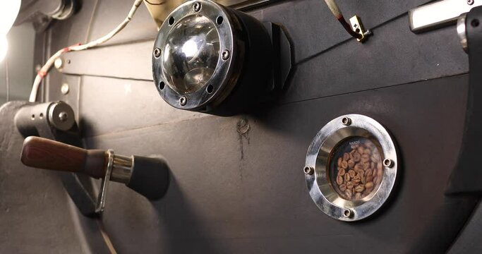 Industrial coffee roasting machine. You can see the process of roasting coffee through a special window. Modern equipment. Coffee production concept.
