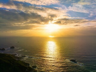 Aerial view of a beautiful bright sunset sky over the Pacific Ocean shore