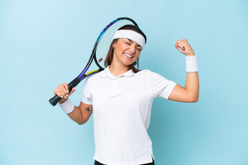 Young tennis player woman isolated on blue background doing strong gesture