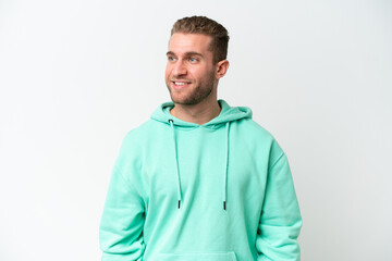 Fototapeta premium Young handsome caucasian man isolated on white background looking to the side and smiling