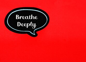 Black sticker on red copy space background with text written Breathe Deeply, self reminder to calm...