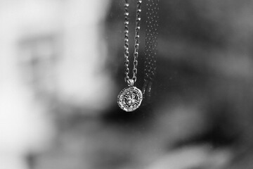 Closeup grayscale shot of a necklace on a blurred background
