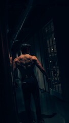 Obraz na płótnie Canvas man performing pull ups in the dark gym with heavy equipment
