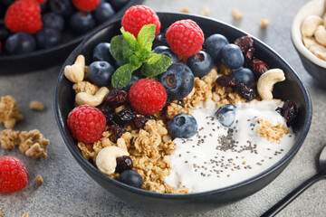 Dry granola with blueberries and raspberries with chia seeds yogurt. Healthy breakfast meal