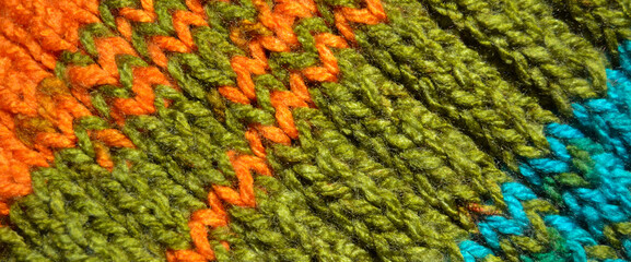 Handmade knitted fabric turquoise  orange and green wool background texture