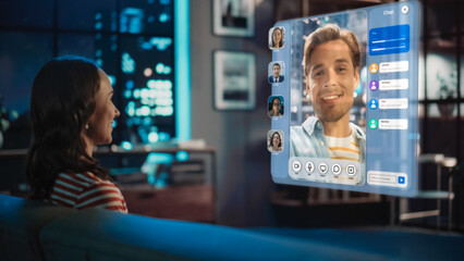 Young Woman Using Augmented Reality Software At Home, Sitting on a Couch in Living Room, Making Gestures to Answer AR Video Call Chat with Friends, Family. Female Talking on Online Meeting.