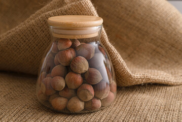 hazelnut inside glass container on burlap background