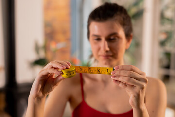 Woman checking results after waistline measuring. Dieting concept, losing weight, calorie control