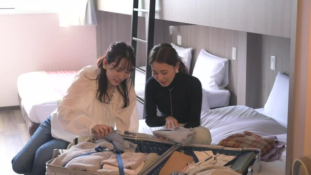 旅行先のホテルで荷ほどきする女性達