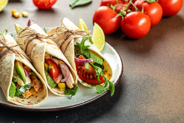 Mexican grilled chicken, avocado, fresh tomatoes, limes Tacos with Vegetables and Corn, Set of burritos or tacos. place for text, top view