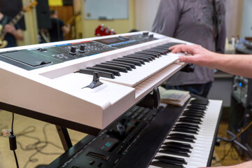 A pianist or keyboardist plays a synthesizer