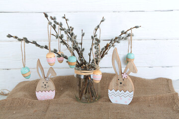 Osterstrauch mit Palmzweigen und Eiern aus Holz mit Hasen Dekoration zu Ostern