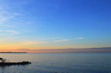 Sunset on the lake, calm water. Lake Geneva at sunset, Evian, France