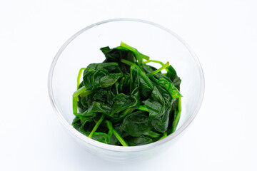 Boiled spinach in glass bowl on white background.