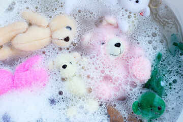 Soak toy teddy bears in laundry detergent water dissolution before washing.  Laundry concept, Top view