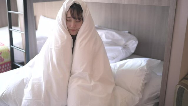 布団にくるまっている可愛らしい女性のポートレート