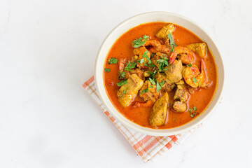 Thai Seafood Curry with Fish and Shrimp in a Bowl Top Down Photo on White Background