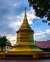 Fototapeta premium Majestic golden pagoda standing in The Navel City Pillar against a backdrop of the sky